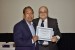 Dr. Nagib Callaos, General Chair, giving Dr. Jesús Salvador Vivanco the best paper award certificate of the session "Qualitative Research and Integrating Academic Activities I." The title of the awarded paper is "Challenges for Using IT in Mexico's Health Care Industry (Aguascalientes México Case)."